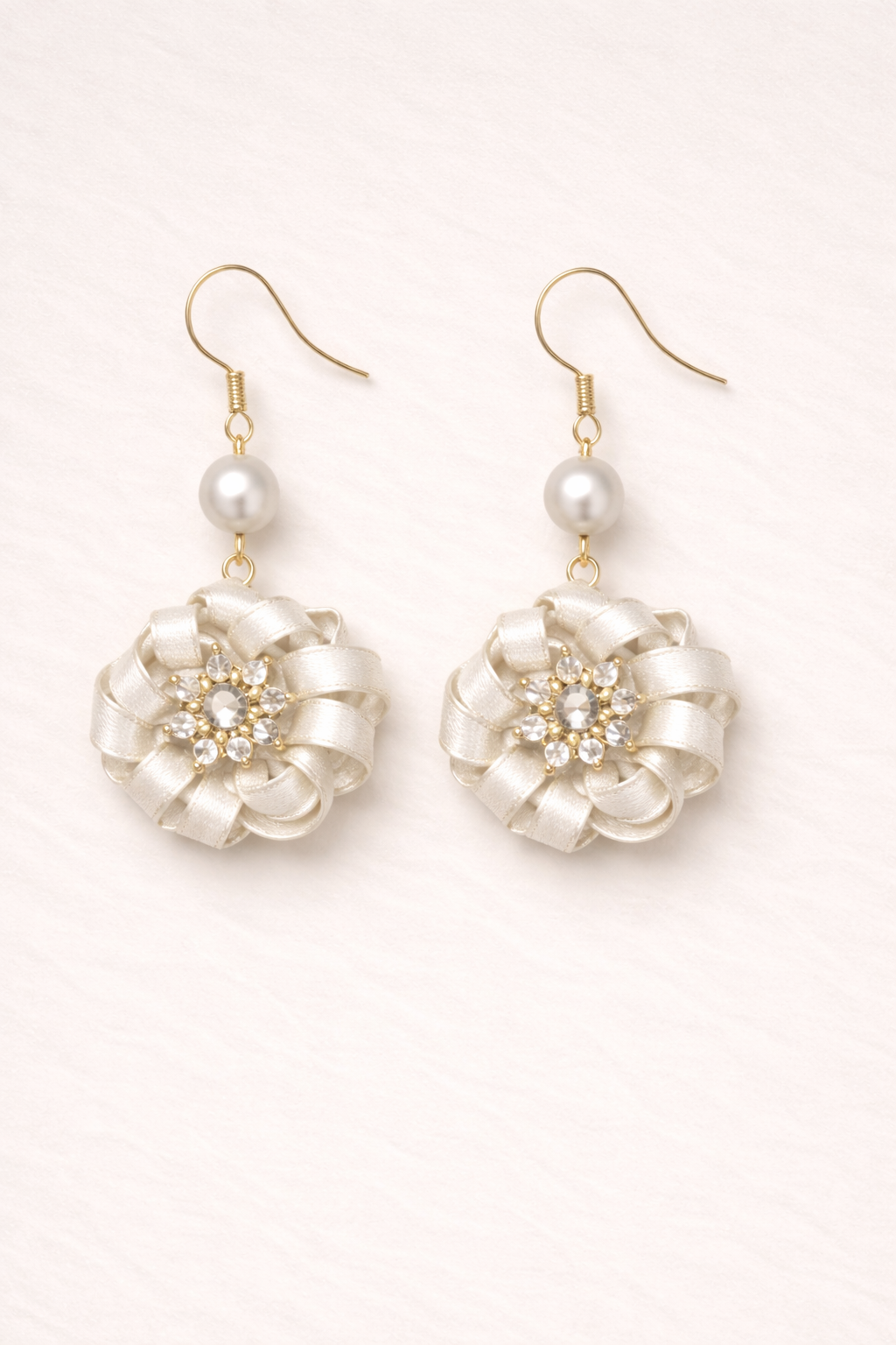 Pair of pearl and crystal earrings on a light background